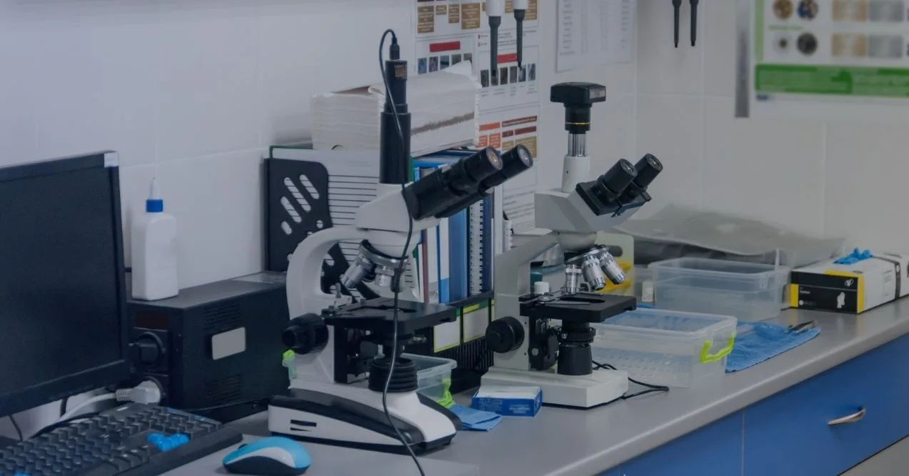 Photo of a scientific lab with microscopes, computers, and lab supplies