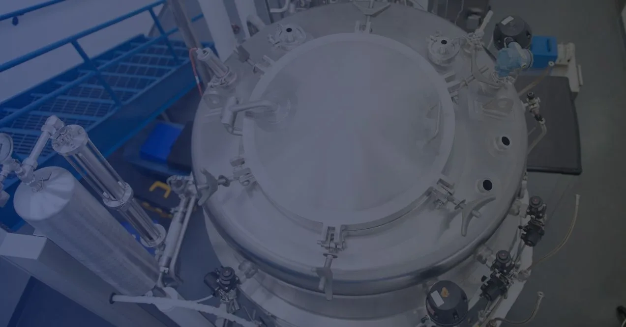 Photo of a clean and modern industrial facility, focusing on a large, cylindrical vessel used in supplement formulation.