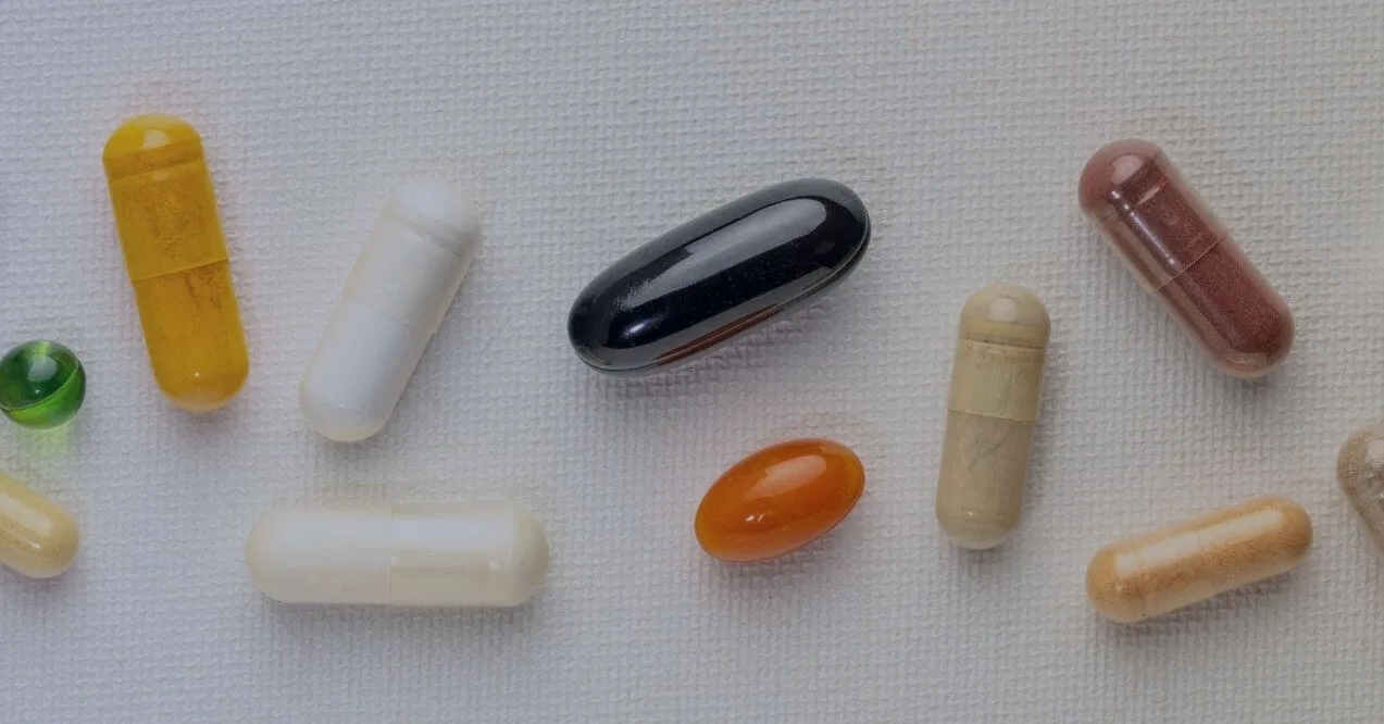 Different types of supplement capsules in various colors and shapes resembling a question: what is the most popular supplement form?